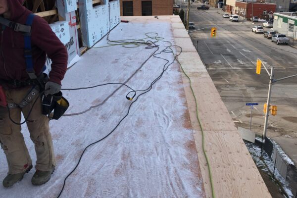 construction worker staning on framing foundation d framing being added for a commercial building - J.R. Construction LTD - midland on